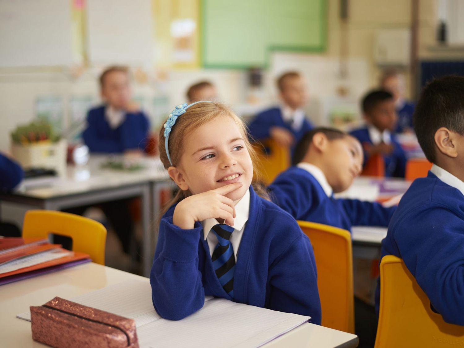 A learner at Queens Church of England Academy in the classroom, smiling.